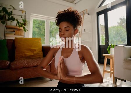 Portrait einer jungen afrikanerin mit geschlossenen Augen, die Yoga praktiziert Mit Gelenkhände Stockfoto