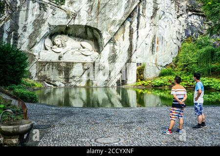 Luzern Schweiz , 29. Juni 2020 : zwei asiatische Touristen tragen chirurgische Gesichtsmasken Blick auf Luzern Lion Denkmal im Sommer 2020 und covid-19 c Stockfoto