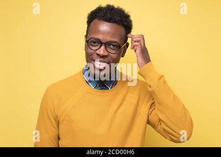 Schöner junger afrikanischer Mann mit Brille lächelnd. Stockfoto