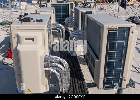 Klimaanlagen HVAC auf einem Dach des neuen Industriegebäudes mit blauem Himmel und Wolken im Hintergrund. Stockfoto