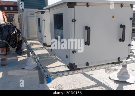 Klimageräte VRV HVAC, großer Ventilator und ein Wasserkühler auf einem Dach des neuen Industriegebäudes mit blauem Himmel und Wolken im Hintergrund. Stockfoto