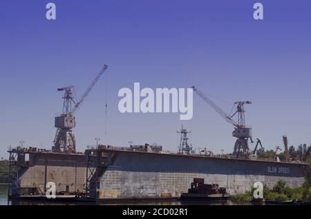 Ein leeres schwimmendes oder Trockendock in einer Werft. Dock für Reparatur und Lackierung des Schiffskörpers. Hebezeuge im Schiffbau. Stockfoto