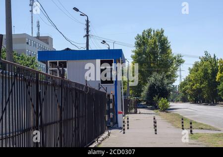 Eingang zum bewachten Parkplatz. Metallzaun mit Stacheldraht. Eingang mit Schranke. Ohne jemanden. Selektiver Fokus. Stockfoto