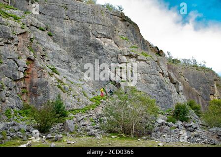 Blick auf Bergsteiger auf Kalksteinklippen im Trowbarrow Quarry Nature Reserve, Silverdale, Carnforth, Lancashire, Großbritannien. Stockfoto