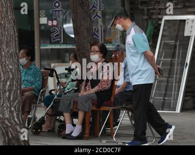 Seoul, Südkorea. August 2020. Ältere Menschen mit Masken ruhen auf einer Straße in Seoul, Südkorea, 25. August 2020. Südkorea meldete 280 weitere Fälle des COVID-19 ab 0:00 Uhr Ortszeit am Dienstag im Vergleich zu vor 24 Stunden, was die Gesamtzahl der Infektionen auf 17,945 erhöht. Quelle: Wang Jingqiang/Xinhua/Alamy Live News Stockfoto