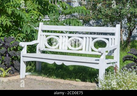 Vintage weiße Holzbank im Garten. Stockfoto