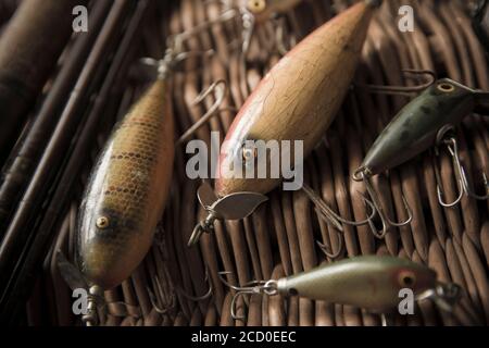 Beispiele für alte South Bend Angeln lockt, oder Stecker, für den Fang räuberischer Fische auf einem Whicker Tackle Box angezeigt. Die größeren Köder sind South Bend Stockfoto