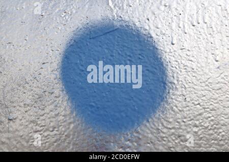 Betonwand Hintergrund mit silberner Farbe und blauen Kreis in der Mitte. Stockfoto