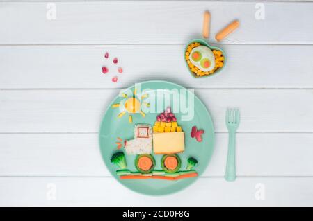 Kids Food Art Konzept: Auto aus Reis, Sandwich und frisches Obst und Gemüse und Auto Form gekochtes Ei auf weißem Holzhintergrund mit leerem Raum fo Stockfoto