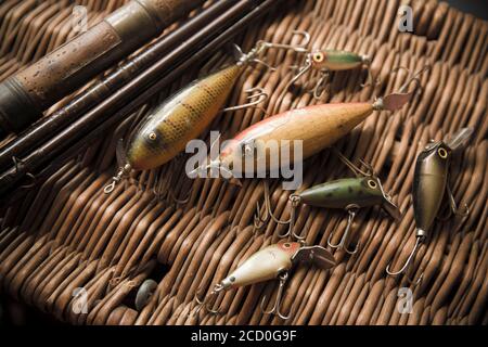 Beispiele für alte South Bend Angeln lockt, oder Stecker, Raubfische auf einem Whicker Tackle Box angezeigt zu fangen. Die größeren Köder sind South Bend Stockfoto