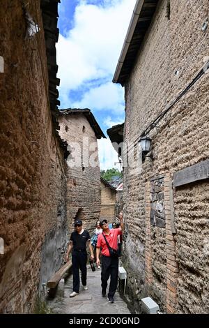 (200825) -- FUZHOU, 25. August 2020 (Xinhua) -- Touristen besuchen historische Dorfresidenzen im Dorf Chenqiao, Bezirk Zhouning, südöstlich der Provinz Fujian in China, 3. August 2020. Umgeben von hohen Bergen und auf einer steilen Klippe gelegen, ist Chenqiao ein tausend Jahre altes Dorf in der Provinz Fujian, berühmt für seine Täler, Wasserfälle und das Meer der Wolken. Mit einer Höhe von 936 Metern und einer durchschnittlichen Temperatur von 24 Grad Celsius im Sommer ist es auch ein beliebter Sommerort für Touristen. Seit Beginn des Sommers werden immer mehr Besucher zum Wandern hierher gezogen Stockfoto