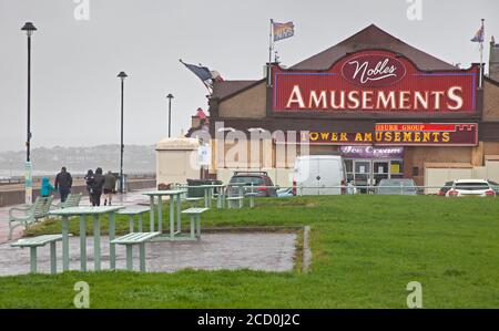 Portobello, Edinburgh, Schottland, Großbritannien. 25. August 2020. Miserable Bedingungen am Meer mit sehr stürmischen Wind und treibenden Regen Komplimente von Storm Francis, halten die meisten Menschen weg von der Küste, aber es gab die seltsam passend gekleideten Fußgänger auf der Promenade zu sehen. Nachdem das Big Ferris Wheel das grüne Licht erst spät am Abend geöffnet hat, liegt es heute wegen des schlechten Wetters geschlossen. Zumindest die Amusement Arcade an der Promenade ist nun nach fünf Monaten der Schließung wegen Covid-19 Einschränkungen geöffnet. Stockfoto