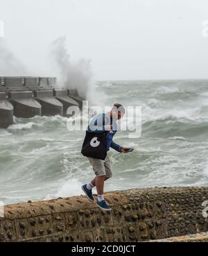 Brighton UK 25. August 2020 - Besucher genießen es zu beobachten, wie Wellen über der Westwand von Brighton Marina bei starken Winden krachen, während Sturm Francis heute durch Großbritannien fegt : Credit Simon Dack / Alamy Live News Stockfoto