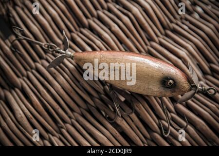 Ein alter South Bend Angelköder, oder Stecker, entwickelt für den Fang Raubfisch fotografiert gegen den whicker Deckel eines alten Tackle Box. Aus einer Sammlung Stockfoto