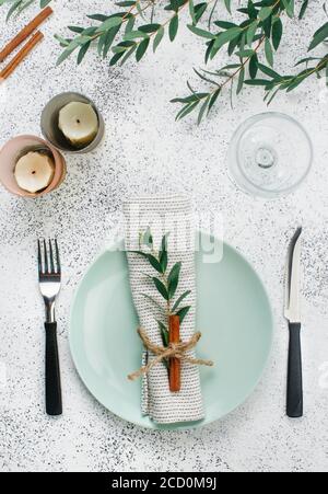 Holiday elegante Tischausstattung mit Leinenserviette, Zweig und Zimt. Draufsicht, flach liegend. Stockfoto