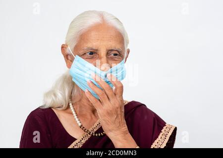 Reife indische Dame trägt Covid-19 Schutzmaske, ältere indische Frau trägt Gesichtsmaske Stockfoto