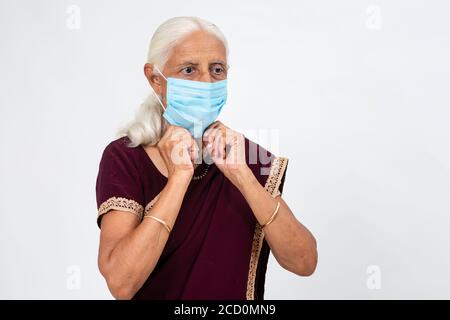 Reife indische Dame trägt Covid-19 Schutzmaske, ältere indische Frau trägt Gesichtsmaske Stockfoto