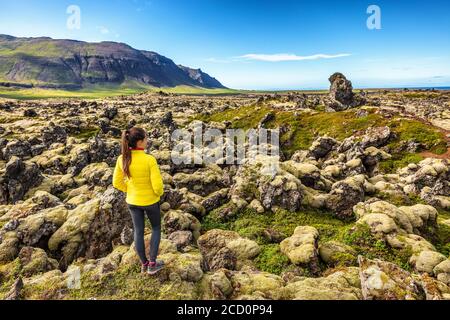 Island Reise - Frau Wandern auf Lavafeldern in Island mit Moos bedeckt - erstaunliche Naturlandschaft. Sommerurlaub Stockfoto