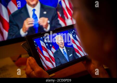 Ein Wähler beobachtet Senator und demokratischer Präsidentschaftskandidat Joe Biden geben seine Dankesrede auf der virtuellen Demokratischen Nationalversammlung am Donnerstag, 20. August 2020. (© Richard B. Levine) Stockfoto