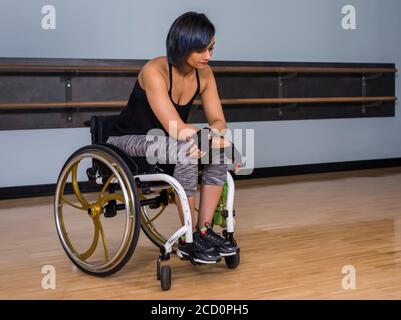 Eine querschnittsgelähmte Frau, die entmutigt aussieht, während sie eine Pause vom Sport in einer Erholungseinrichtung macht: Edmonton, Alberta, Kanada Stockfoto
