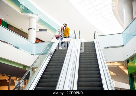 In voller Länge Körpergröße hinten zurück hinter Ansicht von ihr Sie seine er schön attraktiv fröhliche Paar Besuch Retail-Stadt Modernes Gebäude mit Rolltreppe Stockfoto