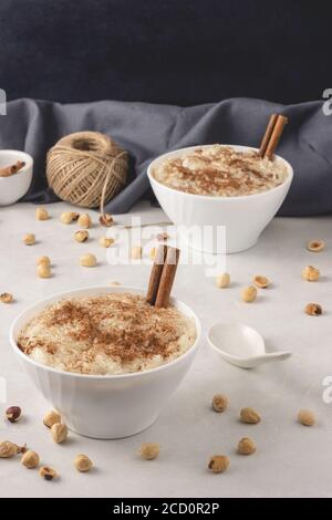 Köstlicher Dessert Rise Pudding mit Zimt und Rosinen in Schüsseln, Nahaufnahme. Serviert und fertig zum Essen. Stockfoto