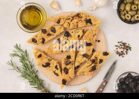 Focaccia Brot mit Oliven, Knoblauch, Oregano und Olivenöl, Draufsicht, flach legen. Stockfoto