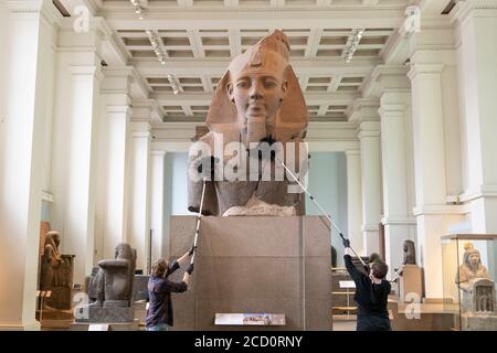 London, England. August 2020. Das Reinigungspersonal staubt den Kopf von König Ramesses im British Museum. Das British Museum wird seine Türen für die Öffentlichkeit im Einklang mit den Richtlinien der Regierung und mit neuen Sicherheitsmaßnahmen wieder öffnen. Nach fünf Monaten Schließung aufgrund der Coronavirus-Pandemie wird das British Museum am 27. August 2020 seine Pforten wieder für die Öffentlichkeit öffnen. Eine neue Einbahnstraße rund um die Galerien im Erdgeschoss ermöglicht den Besuchern den Zugang zu über 9000 Objekten. Weitere Galerien werden später im September wieder eröffnet. (Foto von Sam Mellish / Alamy Live News) Stockfoto