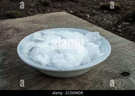 Blume griechischer Meersalzkristalle, Südkreta. Natürliche traditionelle Fleur de Sel von Kreta. Meersalzflocken auf Holzbakkboden. Stockfoto