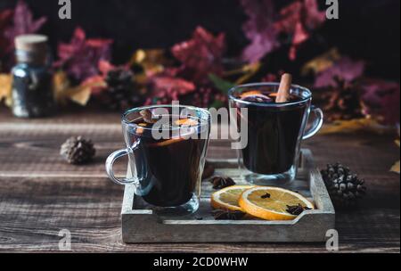 Gemütlicher Herbstdrink. Heißer Glühwein mit Orangen und Gewürzen. Stockfoto
