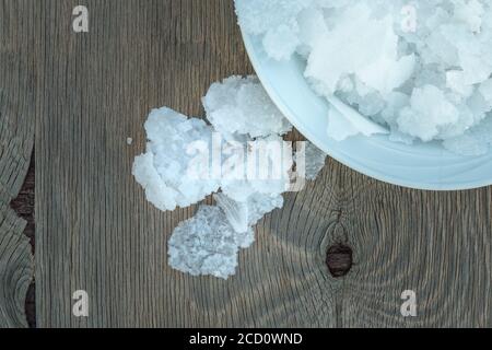 Blume griechischer Meersalzkristalle, Südkreta. Natürliche traditionelle Fleur de Sel von Kreta. Meersalzflocken auf Holzbakkboden. Stockfoto