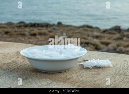 Blume griechischer Meersalzkristalle, Südkreta. Natürliche traditionelle Fleur de Sel von Kreta. Meersalzflocken auf Holzbakkboden. Stockfoto