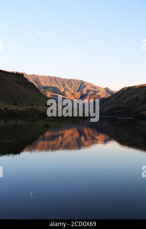 der mond steigt in der Abenddämmerung über dem Oxbow-Damm in idaho auf Stockfoto