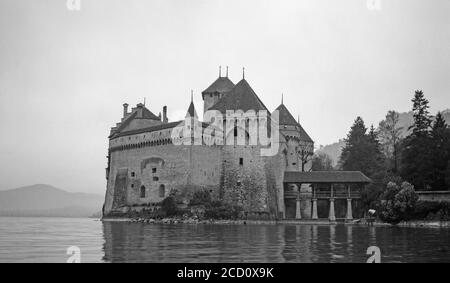 Ein altes Schwarz-Weiß-Foto aus den 1920er Jahren, das Schloss Chillon oder Chateau de Chillon auf einer Insel am Genfer See in der Schweiz zeigt. Stockfoto