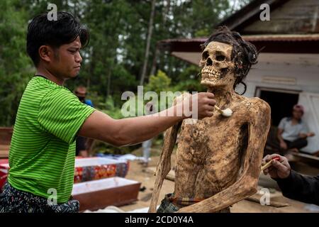 Nord-Toraja, Süd-Sulawesi, Indonesien. August 2020. Familienmitglieder reinigen den erhaltenen Körper ihrer Verwandten während eines traditionellen Rituals namens "Ma'nene" in Panggala, Nord-Toraja, Süd-Sulawesi, Indonesien. Das Ritual findet alle drei Jahre statt, wenn Familienmitglieder sich versammeln, um die Gräber zu reinigen und die Kleidung ihrer verstorbenen Verwandten zu wechseln, um ihren Geist zu ehren. Das Ritual findet vor der Pflanzzeit statt. Quelle: Hariandi Hafid/ZUMA Wire/Alamy Live News Stockfoto