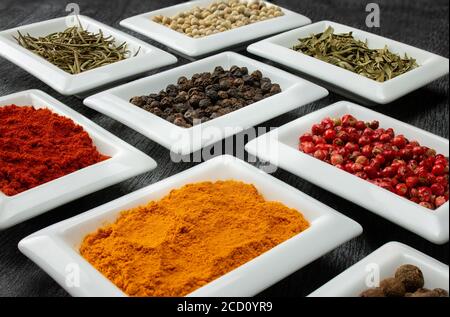 Bunte Gewürze in weißen Schalen Gewürze zum Kochen. Natürliche Kräuter Und Gewürze. Stockfoto