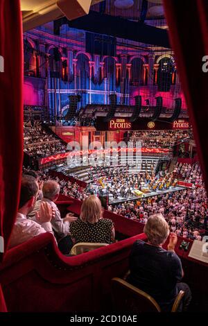 ALBERT HALL INNENRAUM BBC PROMS Performance mit Publikum Beifall klatschen Sheku Kanneh-Mason britischer Cellist, wobei ein Bogen, Erhöhte Ansicht von Luxus rot Velour private, um Publikum und Orchester Bühne Podium hinter London UK Stockfoto