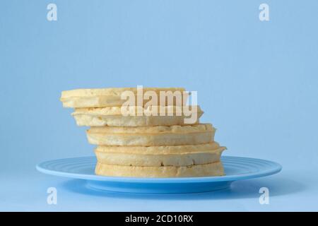 Runde Waffeln zum Frühstück auf blauem Teller gestapelt Stockfoto