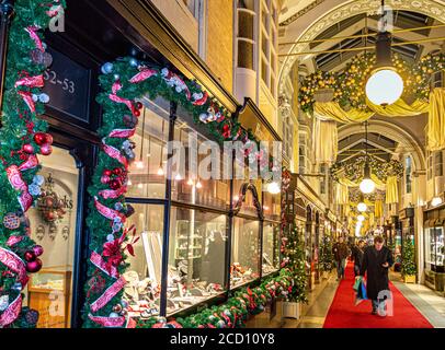 BURLINGTON ARCADE INTERIEUR WEIHNACHTEN SHOPPING SHOPPER INTERIEUR bezauberndes viktorianisches Burlington Arcade in Piccadilly mit traditionellen Weihnachtsschmuck und Shopper London VEREINIGTES KÖNIGREICH Stockfoto