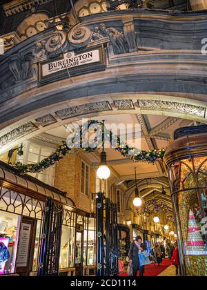 Burlington Arcade Weihnachten traditioneller Luxus London Shopping Arcade Eingang in Piccadilly mit festlichen Weihnachtslichtern Shopper und Dekorationen in der Dämmerung Abends Stockfoto