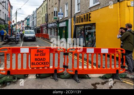 Bantry, West Cork, Irland. August 2020. Bantry Stadt war die vixtim der großen Überschwemmungen letzte Nacht mit mindestens 50 Häuser und Unternehmen leiden erhebliche Wasser-und Schlamm Schäden. Die Überschwemmungen ereignete sich während einer 4-stündigen Regenflut. Die Kraft des Wassers riss einen Teil der Straße in der New Street auf. Cork County Council ist abgebildet, die Notfallreparaturen auf der Straße. Quelle: AG News/Alamy Live News Stockfoto