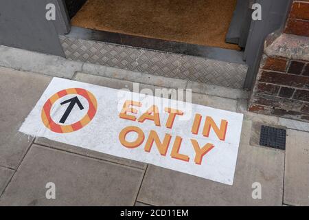 London, England. August 2020. Ein buntes Schild, auf dem steht, dass man nur essen kann, mit einem Richtungspfeil, der nach innen zu einem Café auf einem Straßenbelag in London im Vereinigten Königreich zeigt. (Foto von Sam Mellish / Alamy Live News) Stockfoto