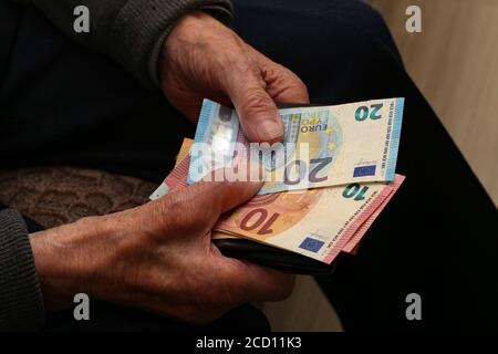 Nahaufnahme eines alten Mannes, der sein Geld zählt Stockfoto