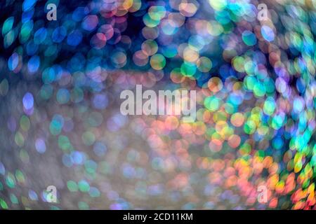 Regenbogen funkeln Glitzer. Abstrakter Hintergrund. Bunt leuchtende Regenbogentropfen und Lichter auf schwarzem Hintergrund. Festlich glänzender Glitzer von verschwommenen Pailletten und Stockfoto