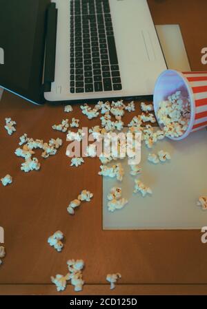 Filmzeit! Popcorn auf dem Tisch neben dem Laptop Stockfoto