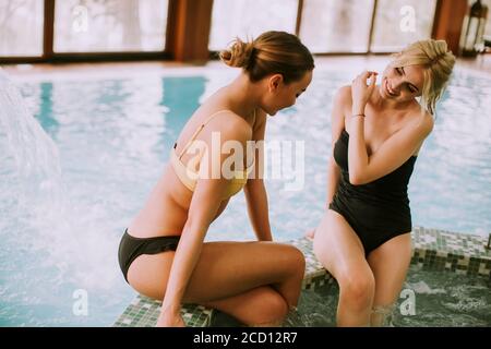 Hübsche junge Frauen sitzen und entspannen an der Whirlpool-Badewanne Stockfoto