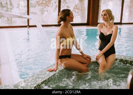 Hübsche junge Frauen sitzen und entspannen an der Whirlpool-Badewanne Stockfoto