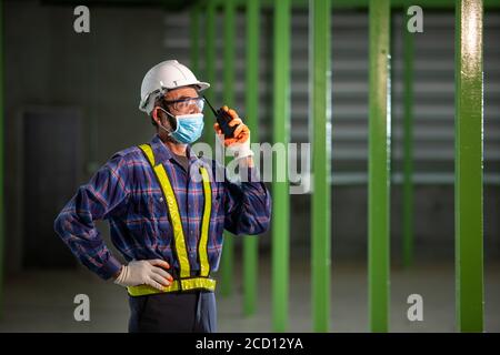 Asiatischer industrieller älterer Mann arbeitet mit einer Gesichtsmaske. Safety for Work Konzept im Werk Stockfoto