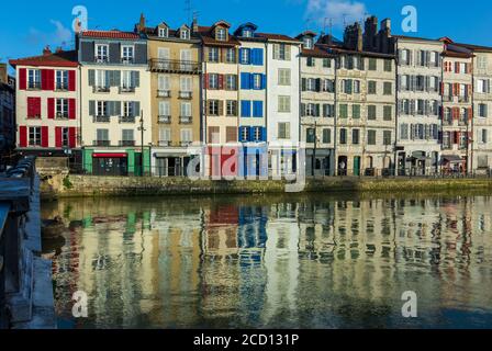 Farbenfrohe baskische Häuser im Viertel "Petit Bayonne" am Ufer des Flusses Nive und ihre Spiegelungen im Wasser. Bayonne, Frankreich Stockfoto