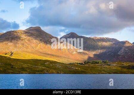 Twelve Bens und Derrylare Lough werden von den Morgenstrahlen der Sonne getroffen; Connemara, County Galway, Irland Stockfoto